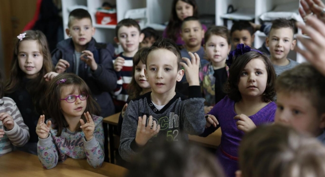 Los alumnos de una clase aprenden lengua de signos para comunicarse con un compañero sordo