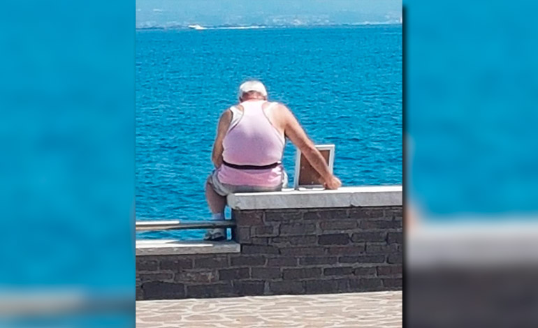 La foto que conmueve a Italia: un hombre frente al mar con el retrato de su esposa